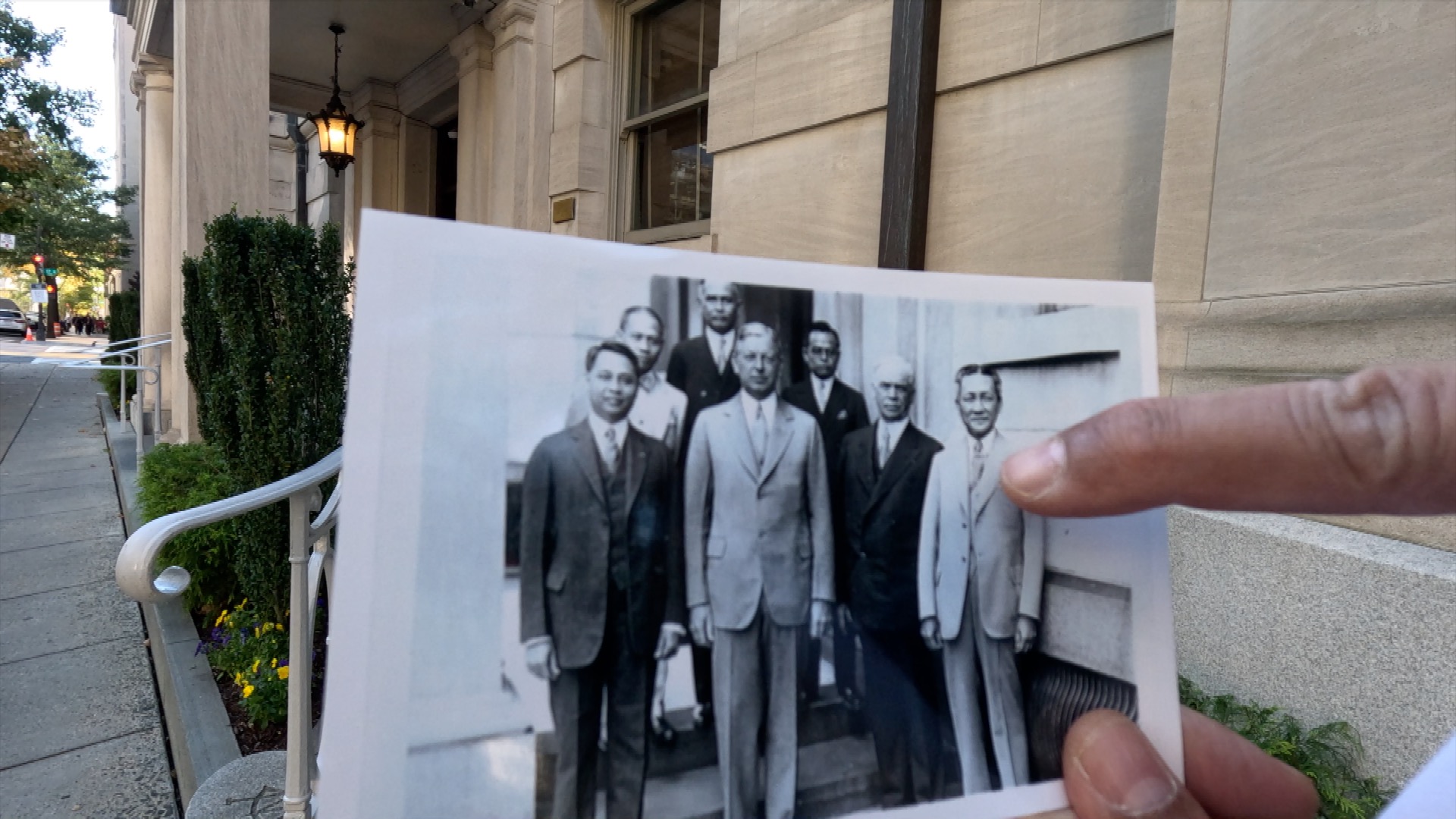 Filipino History in Washington, DC - A person holds a vintage photo of Filipino and American officials, including Carlos Romulo and Dwight Davis, in front of the Metropolitan Club in Washington, D.C.